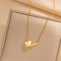 Collar con colgante de corazón dorado pulido sobre joyero beige con textura - Corazón de Doble Hebilla Dorado (423)