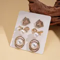 Drei Paar Vintage-Ohrringe in Gold mit Perlen und Strasssteinen auf einer Karte - Goldenes Schleifen-Ohrring-Set (3 Paar)