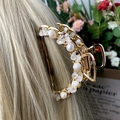 Gouden haarklem met imitatieparels en amethiststenen op blond haar - Wit Kristal + Diepzee Parel Gouden Haarklem