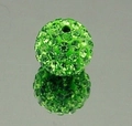 Macro shot of a green clay rhinestone bead with crystals on a reflective surface - Fruit Green