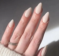 Gros plan d'ongles amande brillants de couleur nude portés avec un pull beige - Rose Nude Élégant (AW289)