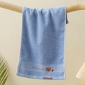 Detailed macro view of soft blue cotton kids towel with cute bear and smile embroidery - Embroidered Bear Head Blue