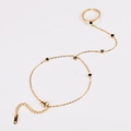 Detailansicht eines goldfarbenen Ring-Armbands mit schwarzen Herzanhängern und Kette - Schwarz Herz-Stil