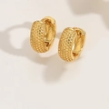 Detailed macro view of golden hoop earrings featuring a unique granulated textured surface - Hammered Texture Style