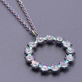 Macro shot of circular rainbow plated stainless steel pendant with white crystals - Rainbow Color Necklace