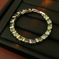 Primer plano de pulsera con circonitas verde oliva y cierre plateado en su estuche - Verde