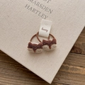 Close-up of cute plush fox hair ties in brown and beige on a decorative book background - Squirrel Hair Tie
