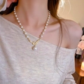 Elegante collana di perle e zirconi con nodo dorato e ciondolo a perla su modella - Stile Placcato Oro 14K / Oro