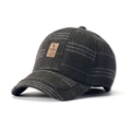 Close-up of vintage grey plaid newsboy cap with wool texture and brown leather label - Big Plaid Grey