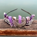 Detailed close-up of a silver moon and branch crown with raw purple crystals on wood - Amethyst