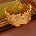 Detail van de gouden klaverarmband met ingewikkeld uitgehold bloemenpatroon kantontwerp - Goud