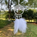 White dream catcher with tree of life crystal design and soft feathers hanging in nature - White Crystal