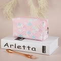 Pink PVC heart pattern makeup bag with wavy quilting on white Arletta book - Pink