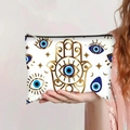 Detail of canvas pouch with gold Hamsa Hand and Evil Eye print held by a model - Hamsa Style