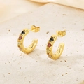 Detail of gold C-shaped earrings with colorful inset stones on natural stone texture - Gold Multi-color Gemstone Style (KE116218-KFC)