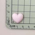 Close-up of pink matte resin heart charm measuring 1.5 cm on a green grid ruler - Light Pink