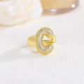 Macro shot of gold letter C ring with micro-pave zircons on a white textured background - Letter C / Gold