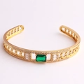 Detail view of gold geometric bracelet with green rectangular zircon and crystal accents - Green Zirconia