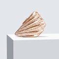 Close-up of shell-shaped acrylic evening clutch bag with marble texture on display - Coffee