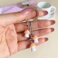 Handheld silver keychain with three small orange resin mushroom charms with white spots - Orange
