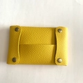 Close-up of yellow litchi pattern leather mini pouch with bronze metal snap buttons - Yellow