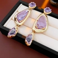 Detailansicht der Vintage-Gold-Ohrringe mit lila Edelsteinen in einer schwarzen Box - Gold