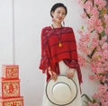 Detailed close-up of red knit poncho featuring rhombus pattern and fringe tassel details - Twill Red