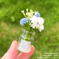 Luminous miniature glass flower bottle with blue flowers held in hand for scale - [Luminous] White + Blue Vase