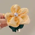 Detail of floral scrunchie featuring yellow satin fabric and large pearl center embellishment - Yellow Flower Scrunchie