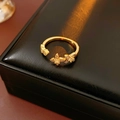 Nahaufnahme eines goldenen Vintage-Rings mit Zirkonblüten und Schmetterlingen auf einer Box - Ring - Gold - Gelb (Echtgoldbeschichtung)