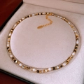 Detailed close-up of baroque pearls and mixed gemstones on a luxury beaded necklace - Necklace - Gold