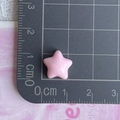 Vista dettagliata di una perla a stella in resina rosa da 1,2 cm su tappetino - Rosa