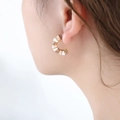 Orecchini a U in titanio dorato con smalto rosa e bianco indossati dalla modella - Cachi