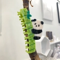 Dettaglio della molletta panda e bambù verde in acetato lucido su un ramo di albero - Panda che tiene il Fermaglio per Capelli in Bambù (Acetato) (Circa 11cm)