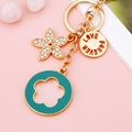 Teal enamel flower keychain with Love Forever engraving on a pink background - Green Five-leaf Clover