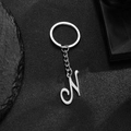 Polished stainless steel keychain featuring a stylish letter N pendant on dark rock - Letter N