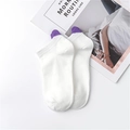 White low-cut cotton socks with purple heart detail on heel, shown on magazine - White Purple