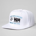 Close-up of vintage Whiskey Ranch Feeders beef theme embroidery on a white flat brim hat - Adjustable / White