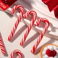 Close-up of red and white striped clay candy cane charms for DIY crafts and decor - Red