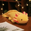 Yellow axolotl plush toy with pink gills in a soft lying position on a wooden table - Type B (Prone Position) / 45cm / Yellow