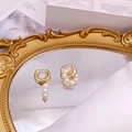 Detailopname van barokke zoetwaterparel oorbellen op een gouden vintage spiegel met zijde - Stijl 1: Ronde Ring Asymmetrische Driedubbele Parelhanger