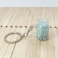 Dettaglio del portachiavi creativo bubble tea verde menta su sfondo in legno - Azzurro