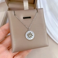 Macro detail of silver four-leaf clover necklace with shell inlay on display card - Titanium Steel Style / Silver