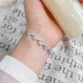Silver star linkage bracelet with white gemstones on a wrist with linen backdrop - Opal Star Bracelet