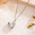 Halskette aus Titanstahl mit rosa Herz-Zirkonia-Anhänger auf weißem Steinboden - Silber Herz Strass Stil