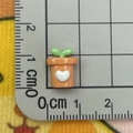 Detailed close-up of a 1.5cm orange resin plant charm on a metric ruler scale - Mini Heart Potted Plant