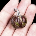 Wizard hat pumpkin pendant in green and reddish-brown natural stone held in hand - Dragon Blood Stone