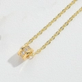 Dettaglio macro del ciondolo a cilindro dorato con zirconi cubici incastonati - Cilindrico (Zircone Bianco Oro)