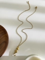 Détail d'un collier avec pendentif hippocampe doré sur un fond blanc minimaliste - Hippocampe