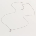 Détail du collier en argent sterling S925 avec pendentifs en zircon scintillant sur fond beige - Argent 925 / Or Blanc
